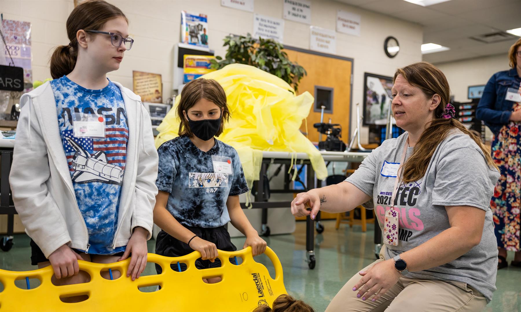 A group of students learns to use a spine board